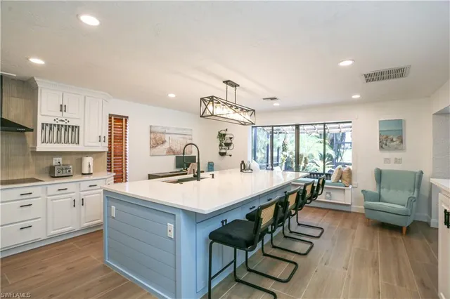 a dining room with stainless steel appliances a table and chairs