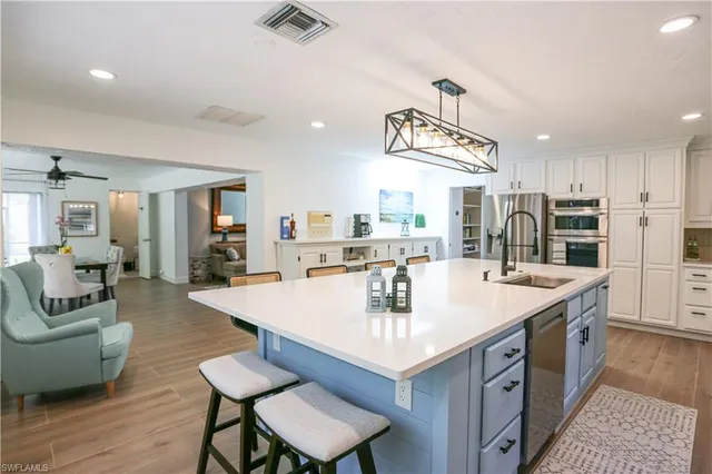 a kitchen with stainless steel appliances white cabinets and wooden floors