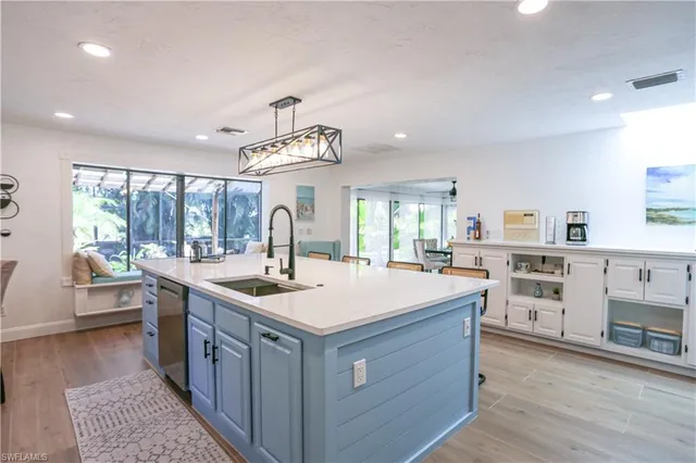 a kitchen with kitchen island granite countertop a sink a stove and cabinets