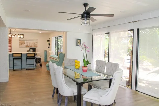 a living room with stainless steel appliances furniture and a wooden floor