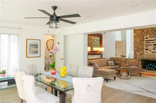 a kitchen with stainless steel appliances a dining table chairs and stove