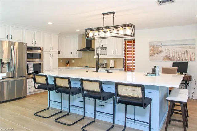 a kitchen with stainless steel appliances a stove a sink a refrigerator and cabinets