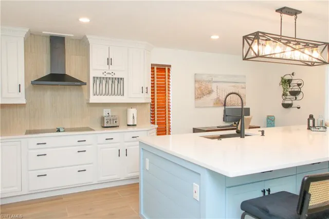 a large kitchen with kitchen island a large window a sink and stainless steel appliances
