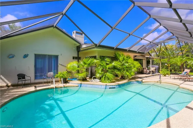 a backyard of a house with a swing chair and potted plants