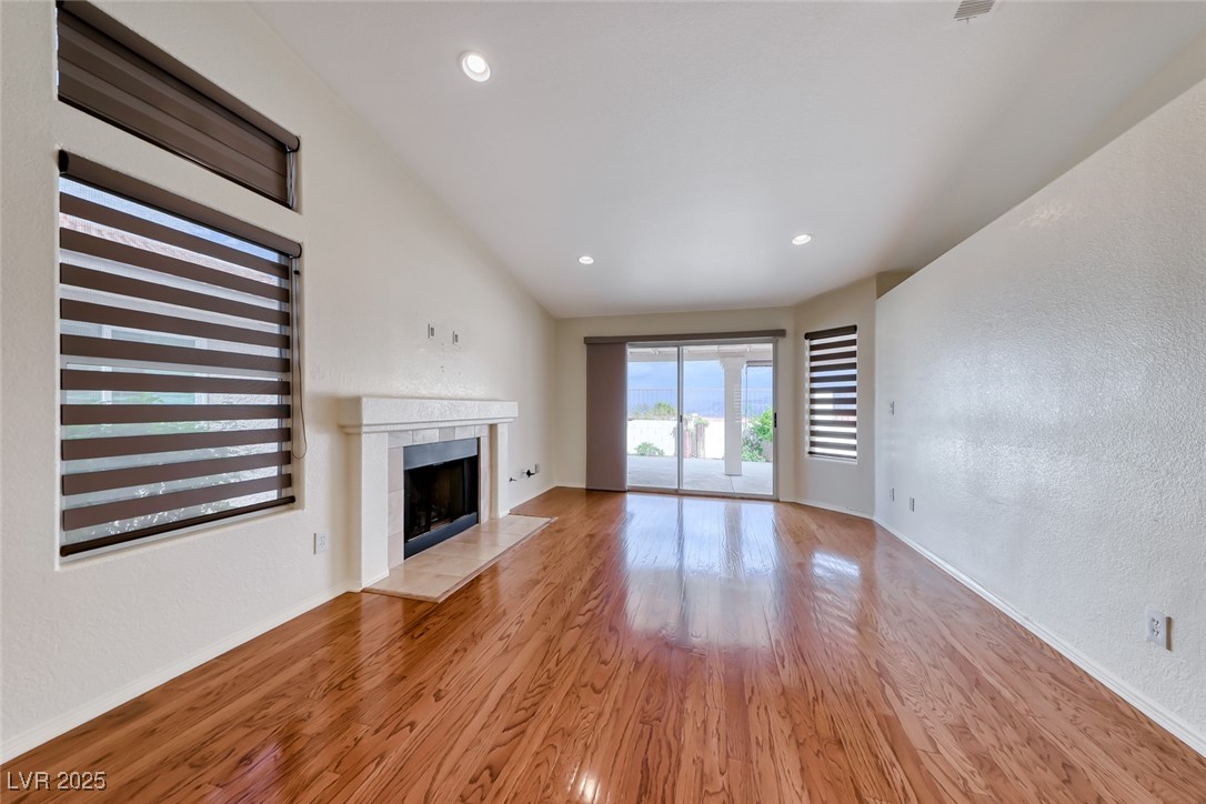 386 Nassau Way Boulder City, NV 89005 - Photo 12 of 44 Unfurnished living room with a textured wall, a tile fireplace, light wood-style flooring, and recessed lighting