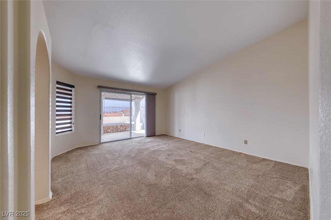386 Nassau Way Boulder City, NV 89005 - Photo 22 of 44 Empty room with carpet floors and lofted ceiling