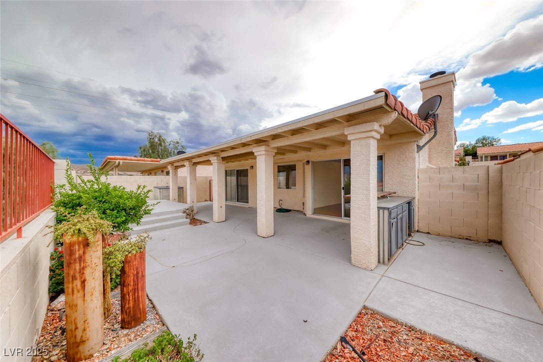386 Nassau Way Boulder City, NV 89005 - Photo 3 of 44 Rear view of house featuring a fenced backyard, a patio area, a chimney, and stucco siding