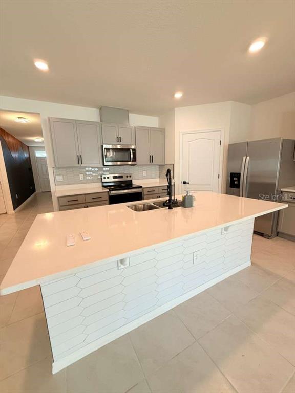 2518 Trinidad Road Haines City, FL 33844 - Photo 6 of 17 a large kitchen with kitchen island granite countertop a sink and white cabinets