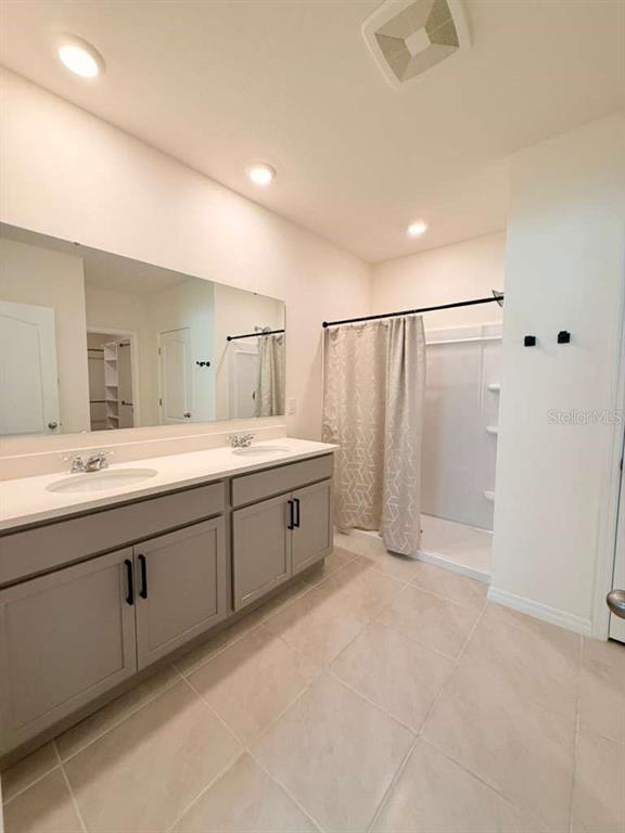 2518 Trinidad Road Haines City, FL 33844 - Photo 10 of 17 a spacious bathroom with a double vanity sink a mirror and a shower