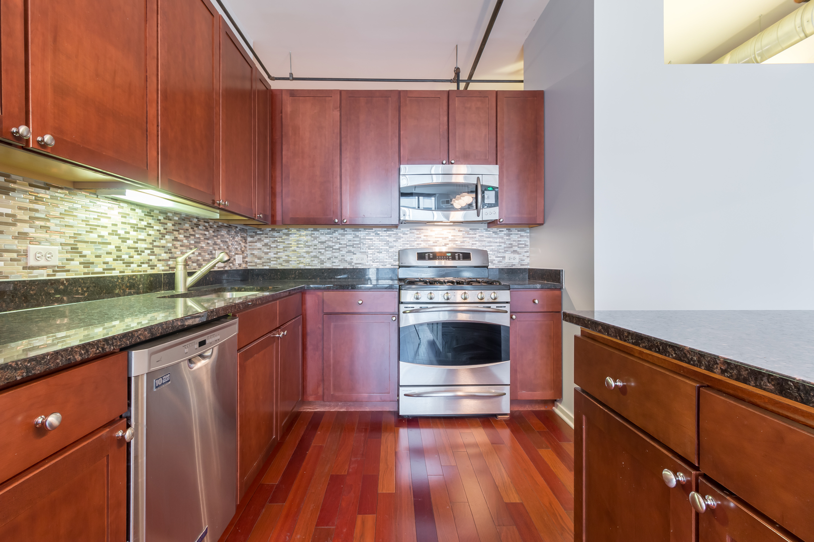520 South State Street, Unit 1403 Chicago, IL 60605 - Photo 12 of 19 a kitchen with granite countertop wooden cabinets and white appliances