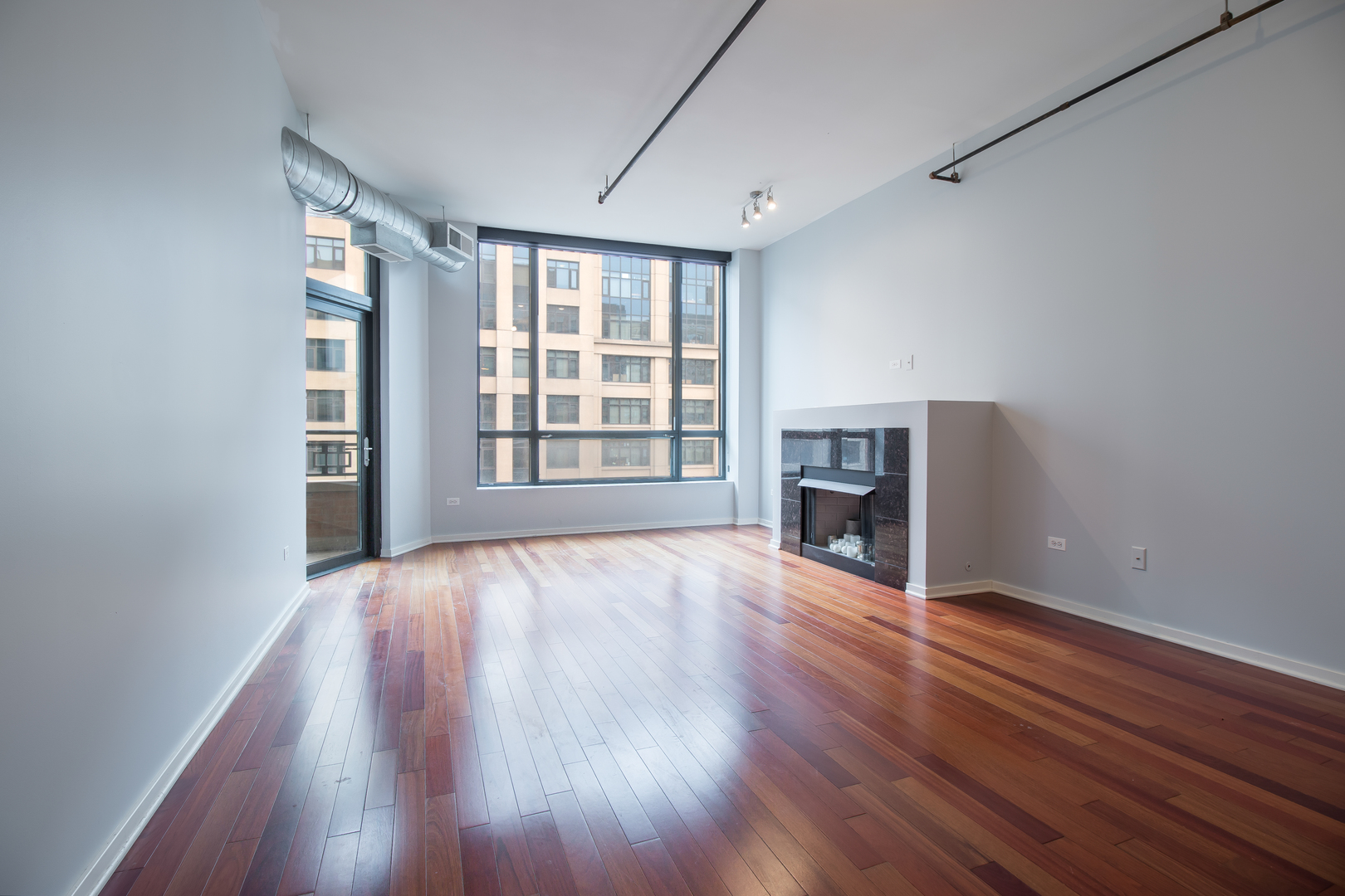 520 South State Street, Unit 1403 Chicago, IL 60605 - Photo 14 of 19 an empty room with wooden floor fireplace and windows
