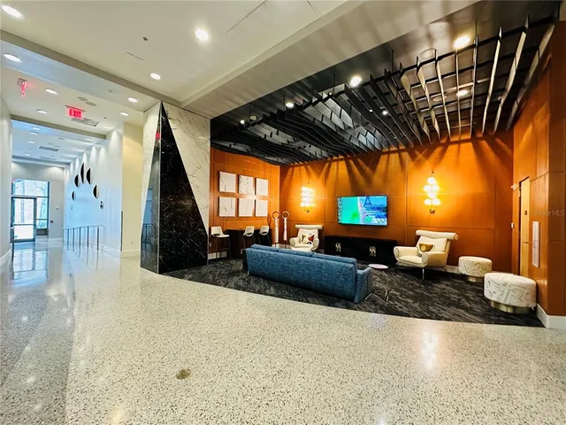 a kitchen with stainless steel appliances kitchen island granite countertop a refrigerator a stove a microwave oven with white cabinets and wooden floor