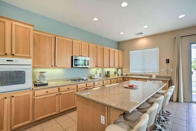 a kitchen with stainless steel appliances granite countertop a sink a stove and cabinets