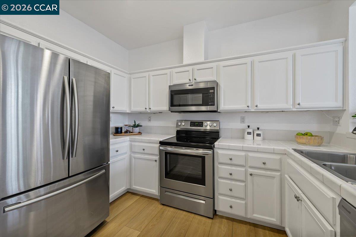7323 Croy Lane Dublin, CA 94568 - Photo 18 of 33 a kitchen with stainless steel appliances a refrigerator stove and white cabinets