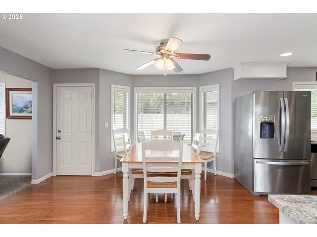 a kitchen with granite countertop a refrigerator and a view of living room