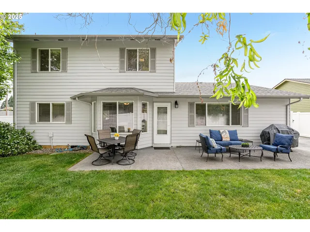 a view of a house with a backyard and sitting area