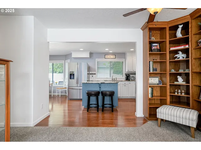a living room with furniture and a dining table with wooden floor