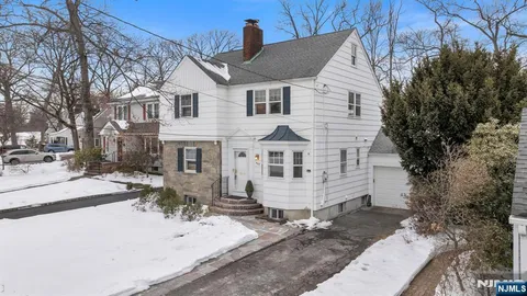 a view of a white house with a yard covered in snow