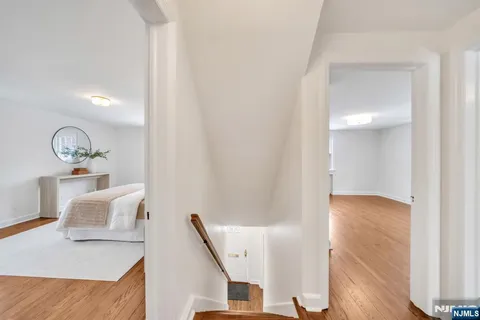 a spacious bedroom with a bed and wooden floor