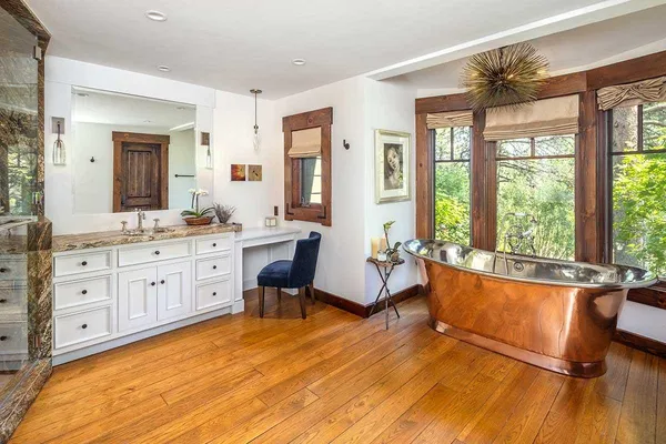 a spacious bathroom with a double vanity sink a mirror and a bathtub