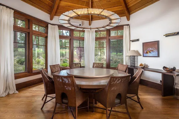 a view of a dining room with furniture large windows and wooden floor