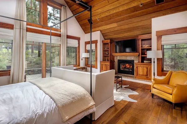 a large bedroom with furniture fireplace and wooden floor