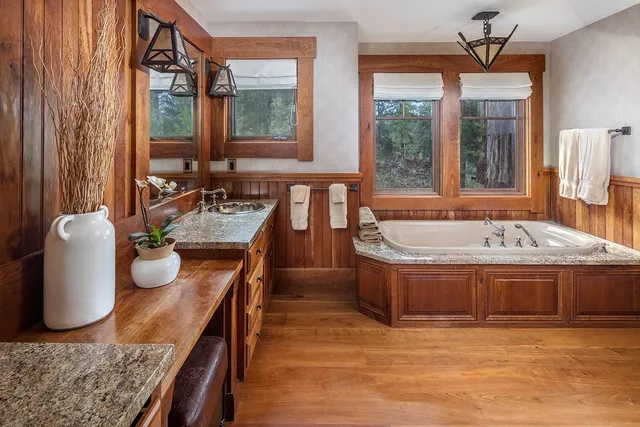 a bathroom with a tub a sink and a window