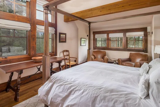 a large bedroom with a bed and wooden floor