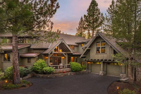 a front view of a house with a yard and lake view