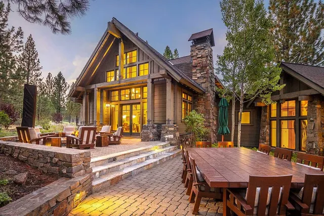 a view of a house with a dining table and chairs in patio