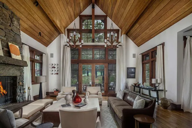 a living room with furniture a fireplace and potted plants