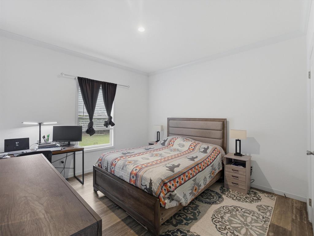 466 Belcher Road Bowie, TX 76230 - Photo 29 of 40 a bedroom with a bed a mirror and desk