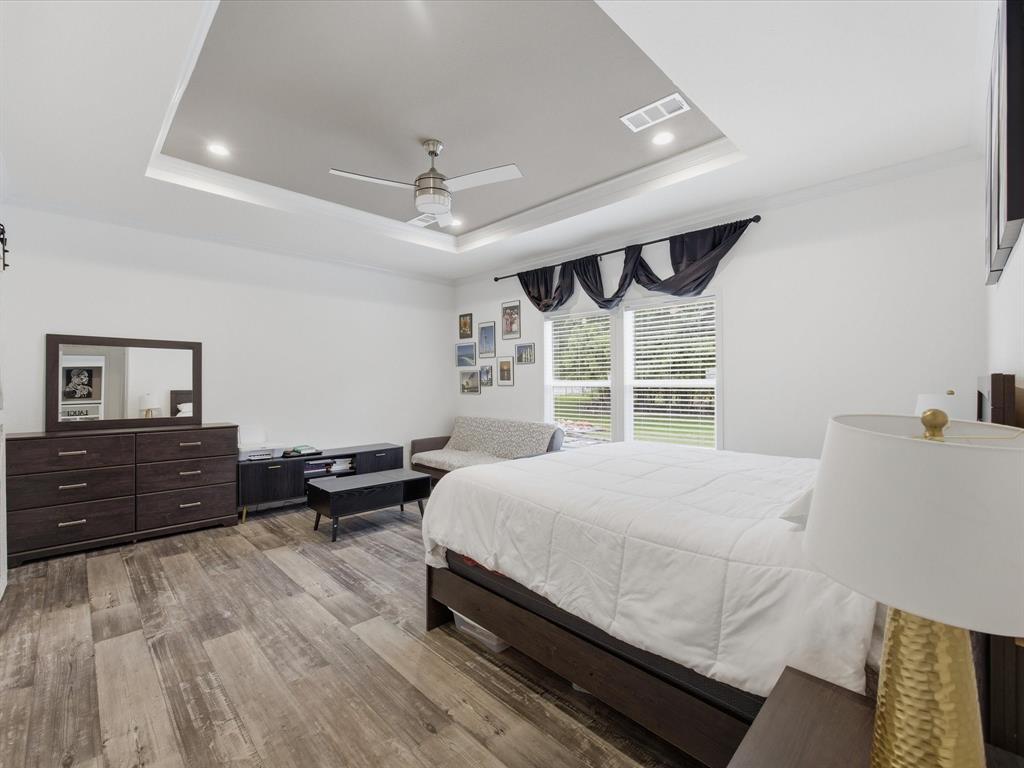 466 Belcher Road Bowie, TX 76230 - Photo 9 of 40 a bedroom with a bed wooden floor and window