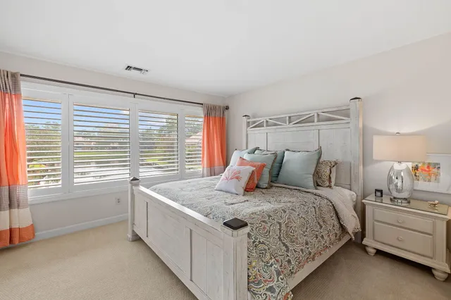 a bed sitting in a bedroom next to a window