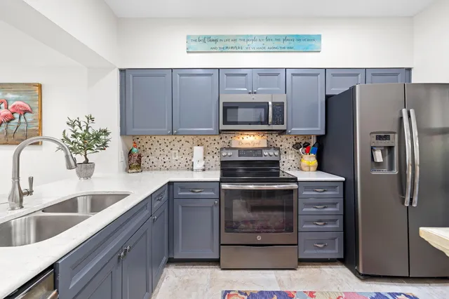 a kitchen with stainless steel appliances granite countertop a refrigerator stove and sink