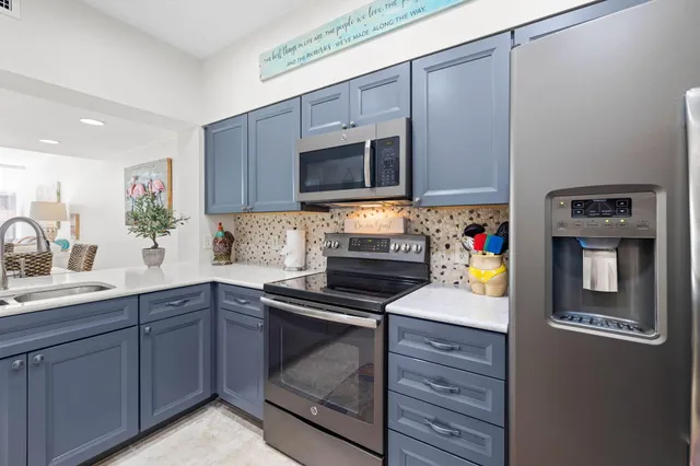 a kitchen with granite countertop a sink stove and microwave