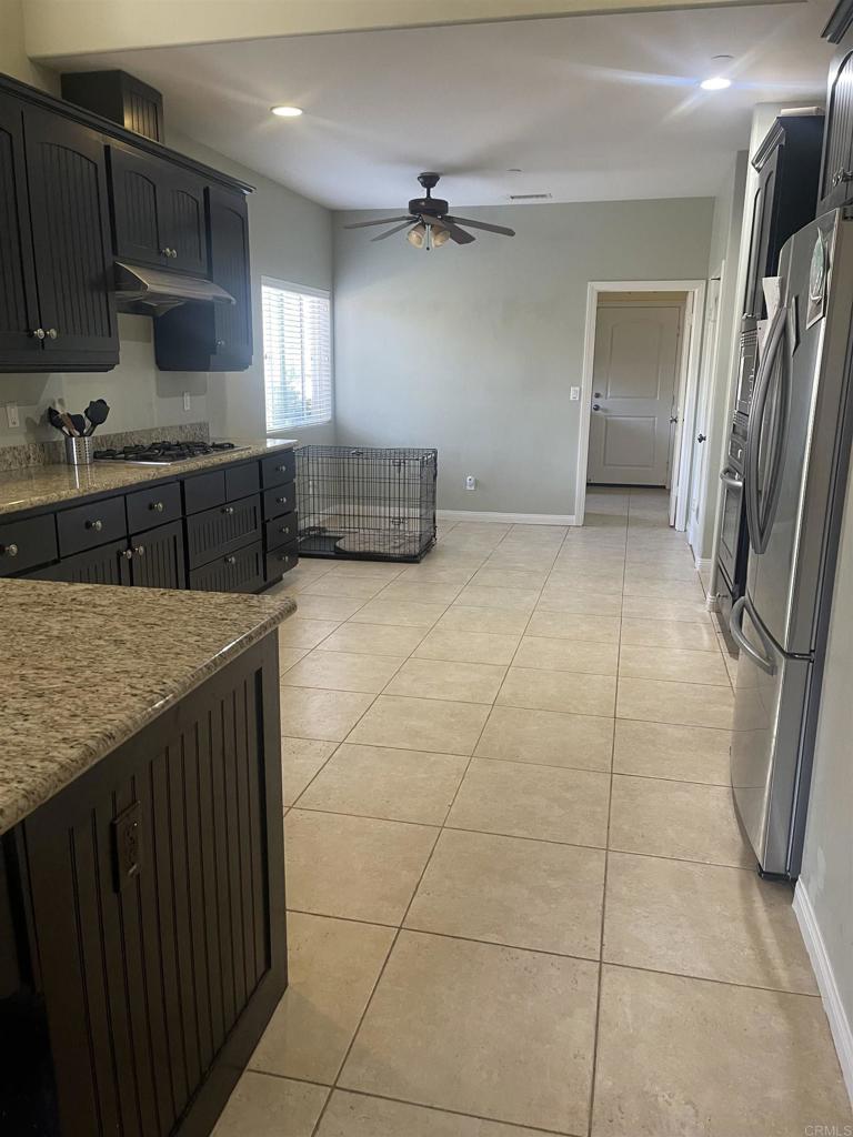 13907 Maxfield Road Jamul, CA 91935 - Photo 15 of 32 a kitchen with stainless steel appliances granite countertop a refrigerator a sink and wooden cabinets