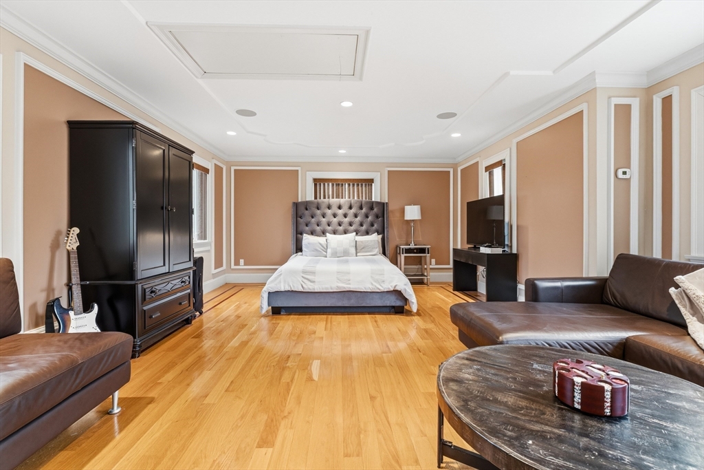 7 Freeman Street Lynnfield, MA 01940 - Photo 33 of 39 a spacious bedroom with a bed a couch and a flat tv screen