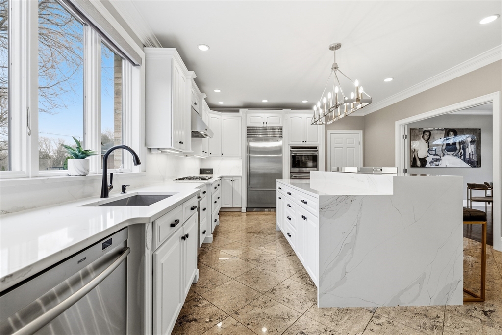 7 Freeman Street Lynnfield, MA 01940 - Photo 7 of 39 a large white kitchen with stainless steel appliances granite countertop a sink dishwasher a stove and a dining table with wooden floor