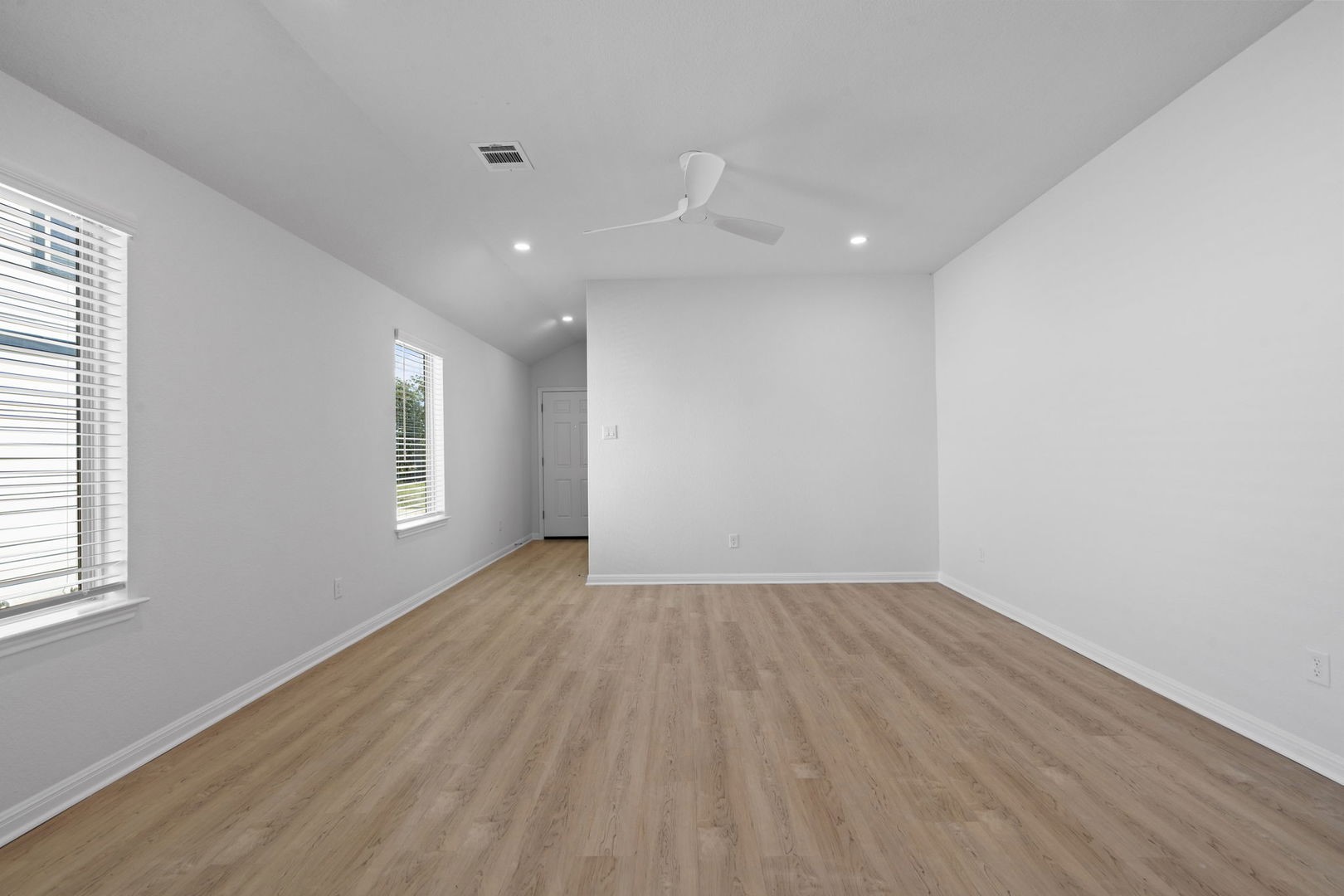 141 Hatari Trail Jarrell, TX 76537 - Photo 8 of 36 an empty room with wooden floor and windows