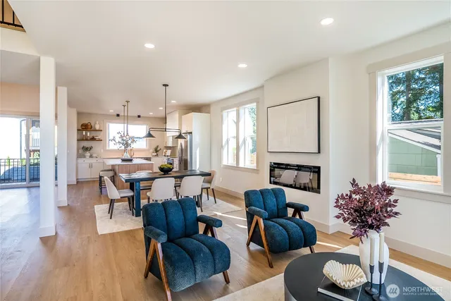 a living room with furniture a fireplace and a large window