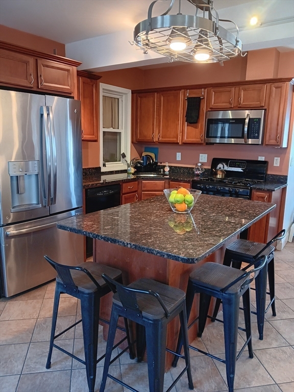 28 Barnard Road Worcester, MA 01605 - Photo 4 of 20 a kitchen with granite countertop a table chairs stove and microwave