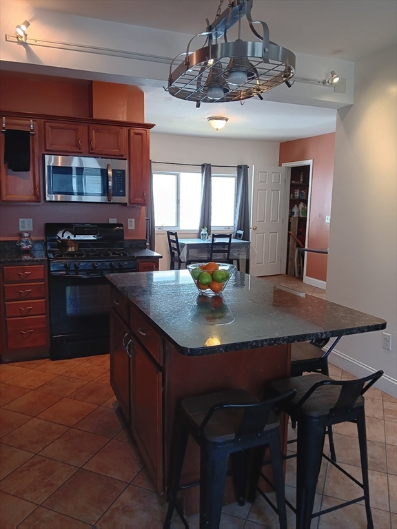 28 Barnard Road Worcester, MA 01605 - Photo 5 of 20 a kitchen with a kitchen island a stove a table and chairs in it