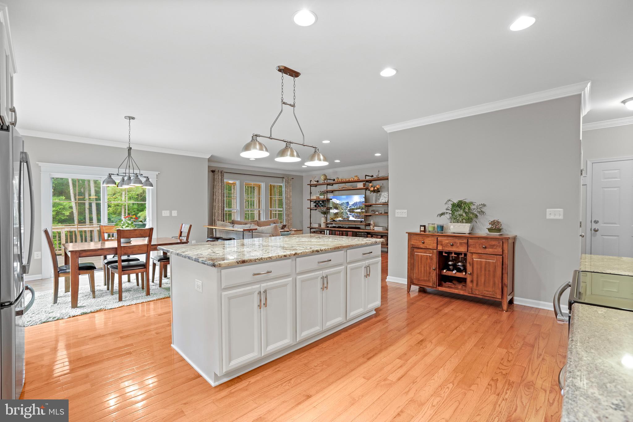 8264 Buckthorne Run King George, VA 22485 - Photo 11 of 50 a kitchen with stainless steel appliances granite countertop a stove oven and a dining table with wooden floor