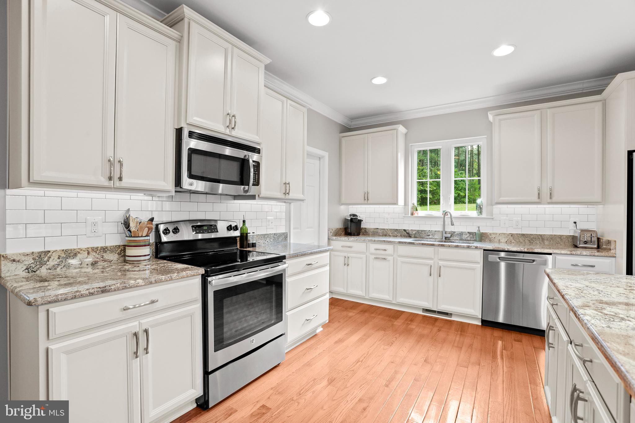 8264 Buckthorne Run King George, VA 22485 - Photo 8 of 50 a kitchen with granite countertop stainless steel appliances white cabinets granite counter tops and a hard wood floors