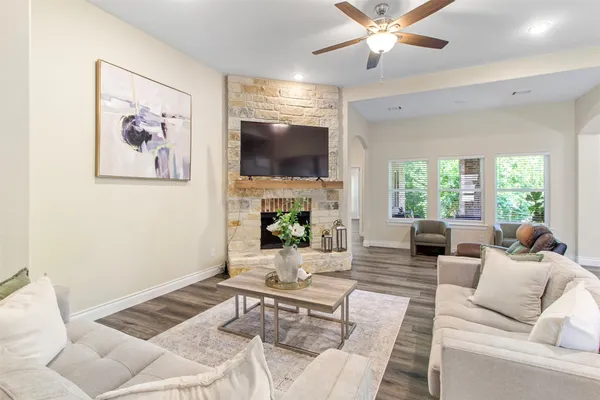 a living room with furniture a flat screen tv and a fireplace