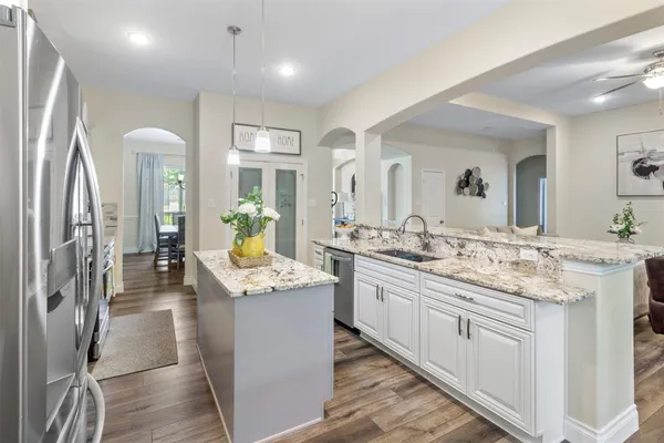 a view of a kitchen counter top space with granite countertop a sink and cabinets