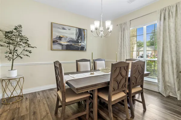 a view of a dining room with furniture a chandelier and wooden floor