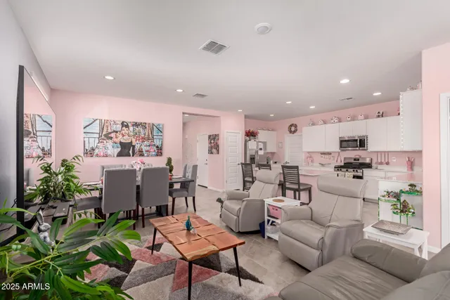 a living room with furniture kitchen and a potted plant