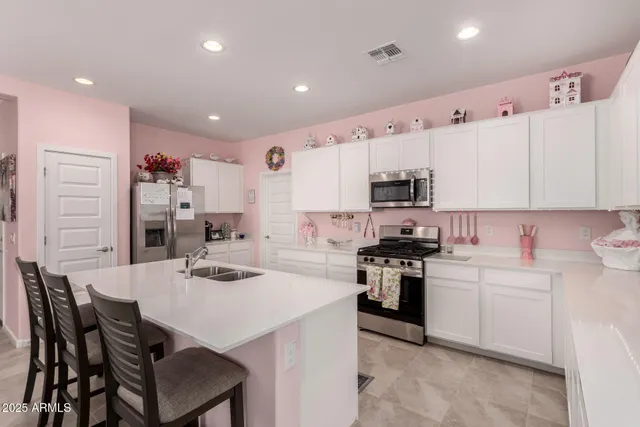 a kitchen with stainless steel appliances kitchen island granite countertop a stove a sink a dining table and chairs